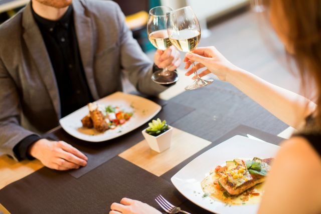 レストランでワイングラスを合わせて乾杯する男女