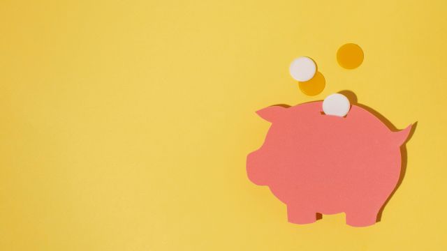 豚の貯金箱にコインを入れるイメージ