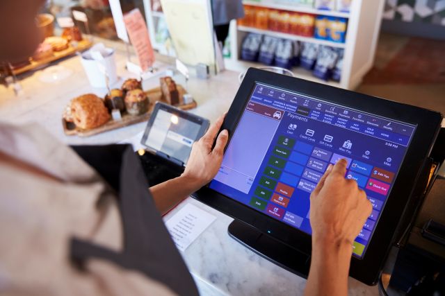 POSレジの画面をタッチ操作する店員のイメージ