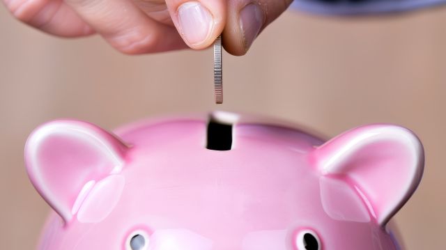 豚の貯金箱に硬貨を入れるイメージ