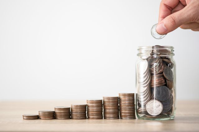 コインタワーと瓶詰になった硬貨のイメージ
