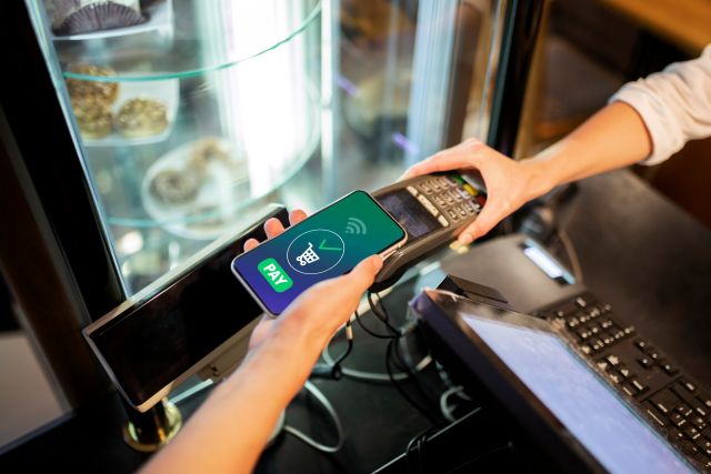 決済端末でスマホ決済する人のイメージ