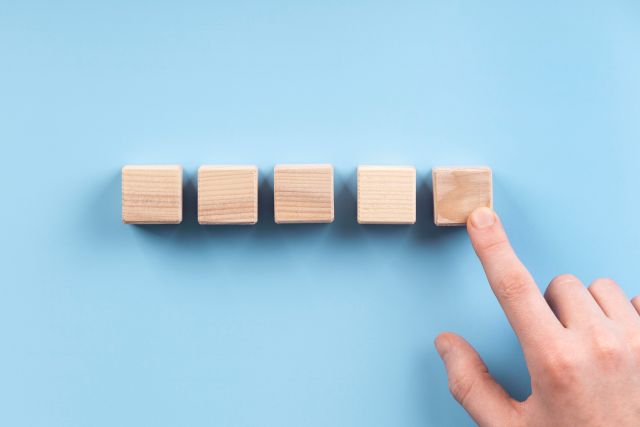 5つ並んだ木製ブロックのうち1つを指さすイメージ