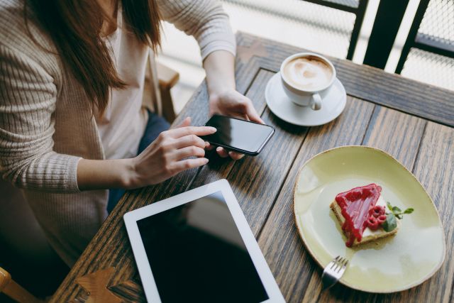 飲食店のテーブルでスマホを操作する女性