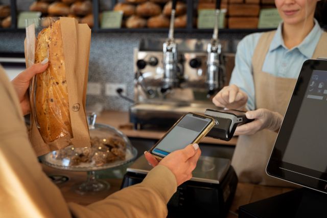 カフェのレジでスマホでキャッシュレス決済をする人のイメージ
