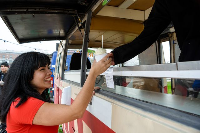 キッチンカーでドリンクを受け取る女性のイメージ