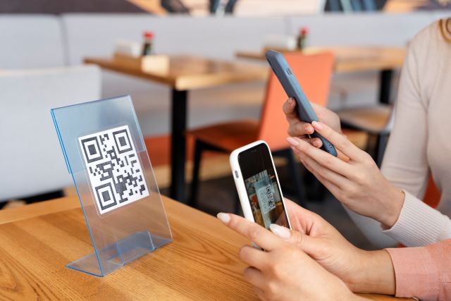テーブル上のQRコードPOPにスマホのカメラを向ける人のイメージ