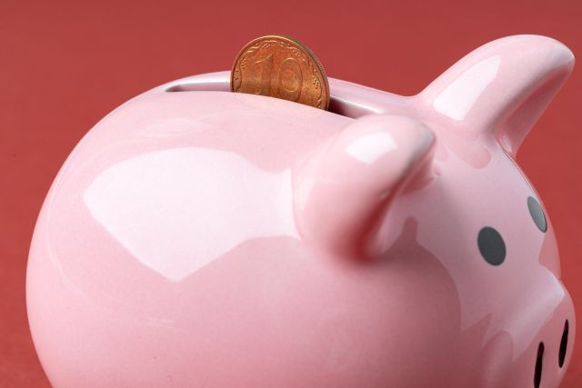 豚の貯金箱にコインが投入されるイメージ