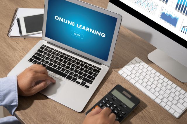 ノートパソコンと電卓を触る手