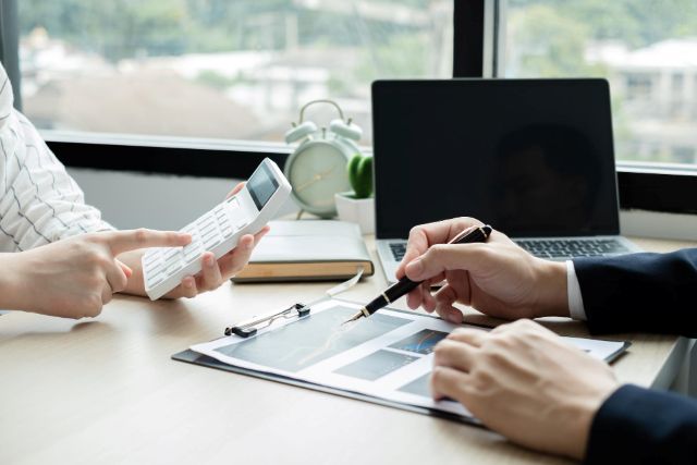 電卓を叩く人と書類に記入する人