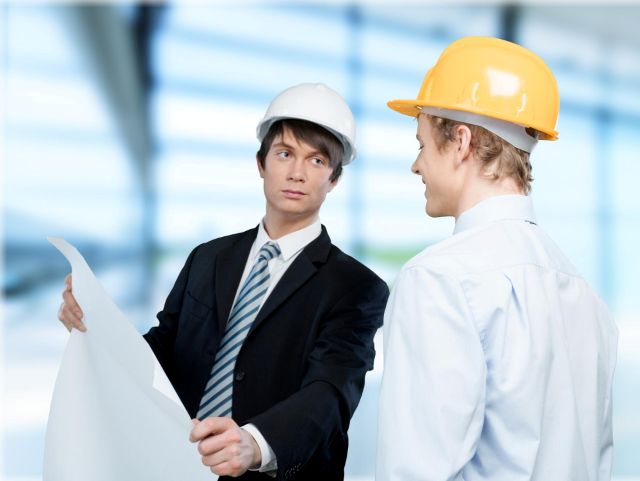 設計図を見るヘルメットのビジネスマン