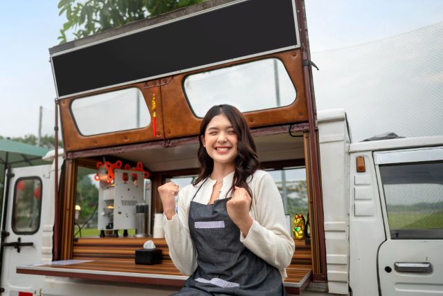 自信を持ってコーヒーショップの前に立つ女性