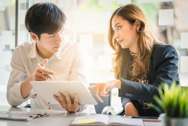 タブレットを見ながら話し合う男女