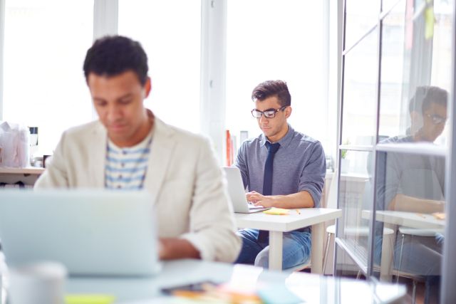 パソコンの前で仕事をする外国人たち