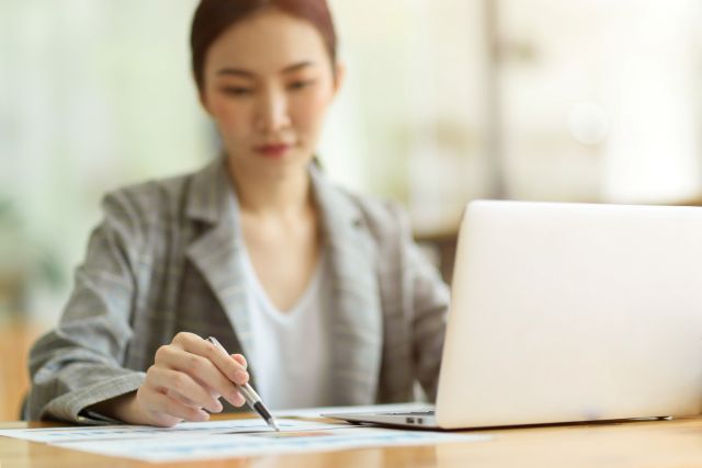 紙に何かを書く女性