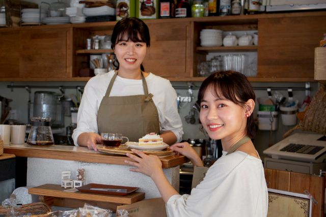 ケーキを持つ店員とお客