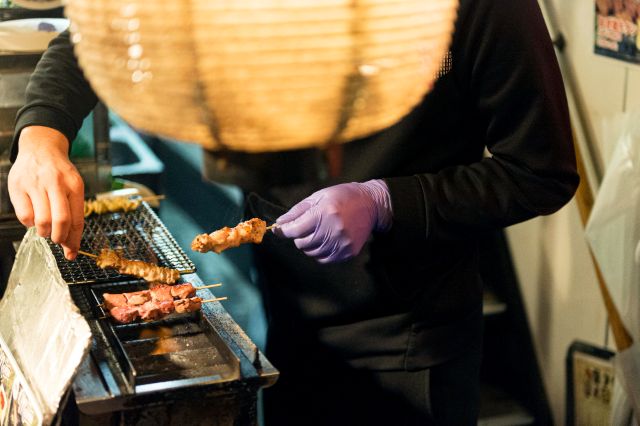 焼き鳥を持つ店員
