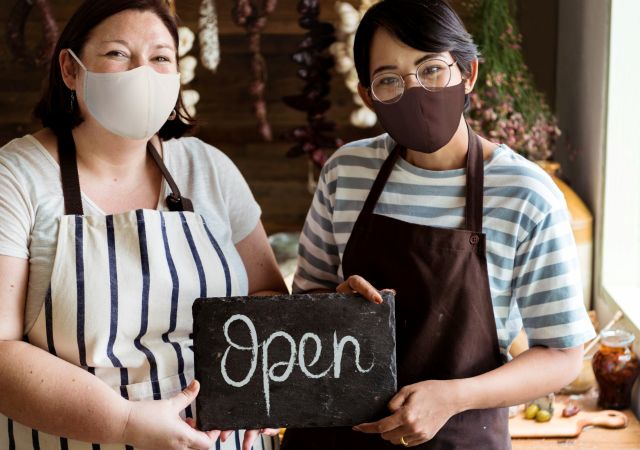Openの文字を持つ女性従業員